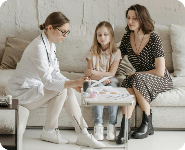 Médica em consulta com mãe e filha, representando serviços voltados para profissionais de saúde.